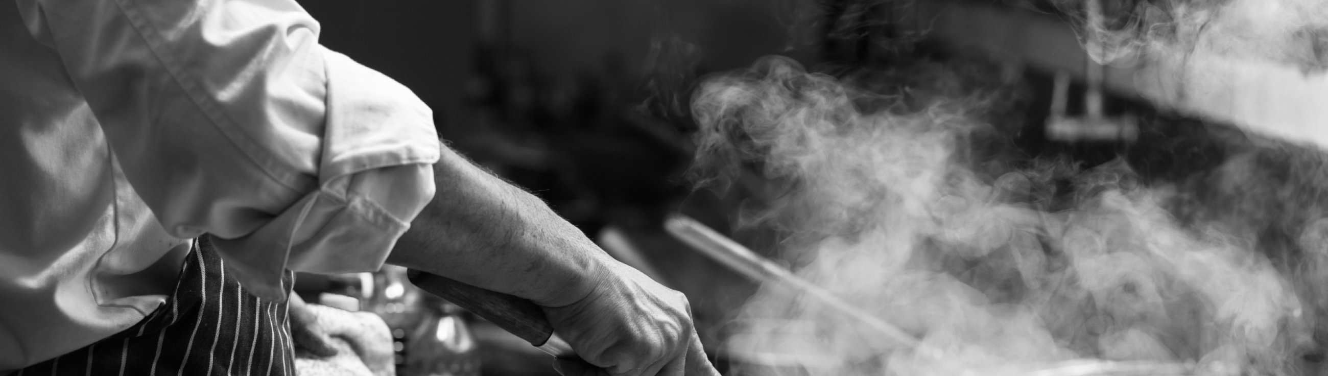 Chef is stirring vegetables in wok,monochrome